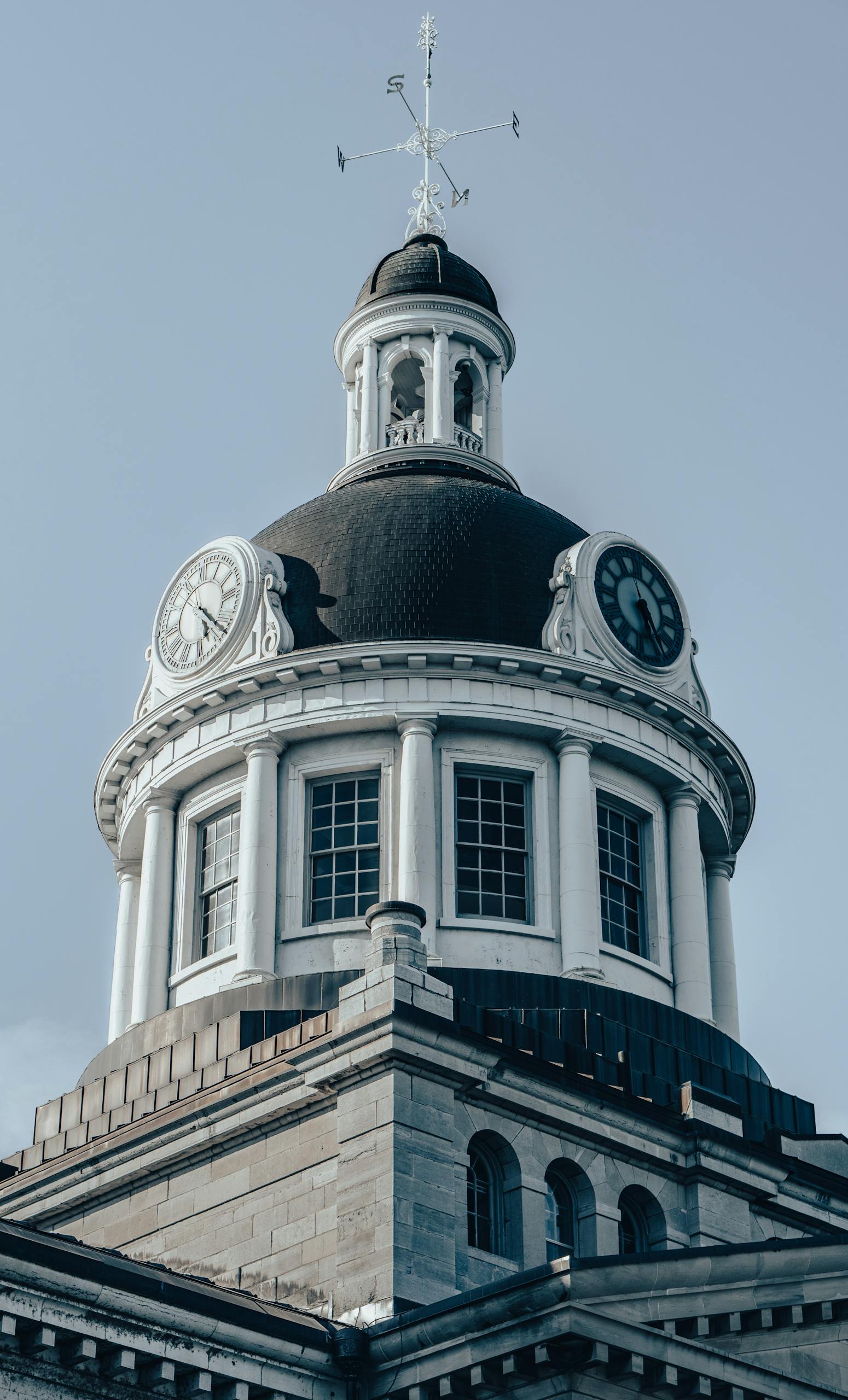 Elegant neoclassical architecture of Kingston City Hall dome captured from a low angle against a clear sky.